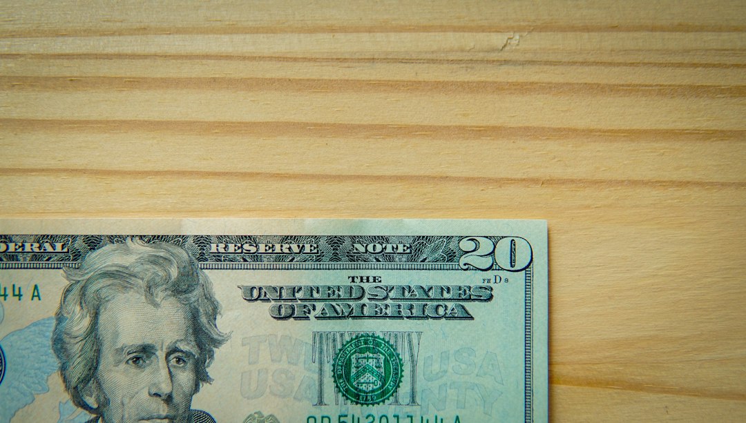 A twenty-dollar bill on a wooden table.