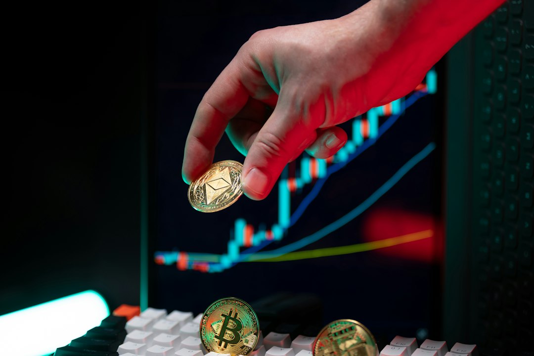 Hand holding ethereum with crypto graphs in background.