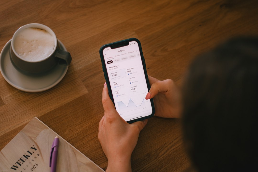 Checking finances on a phone with coffee.