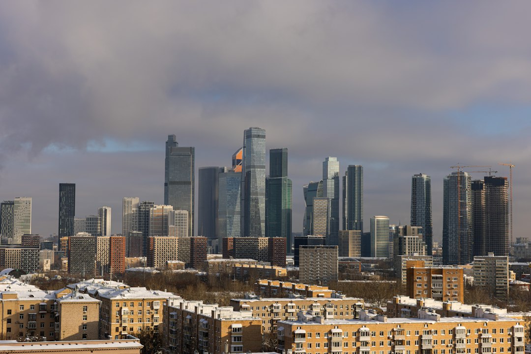 Modern skyscrapers dominate a winter cityscape with snow.